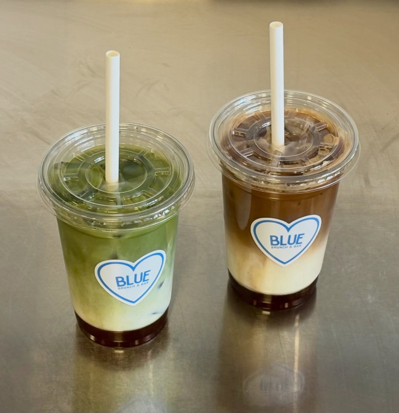 Ismatcha och islatte i take away-glas med Blues hjärtklistermärke