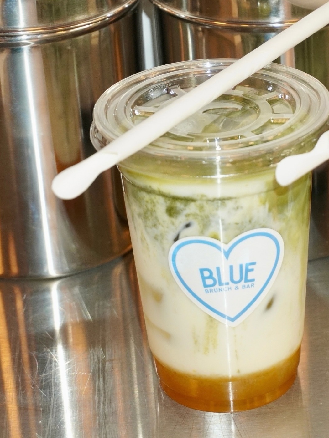 Iced matcha i plastglas med Blues hjärtformade klistermärke